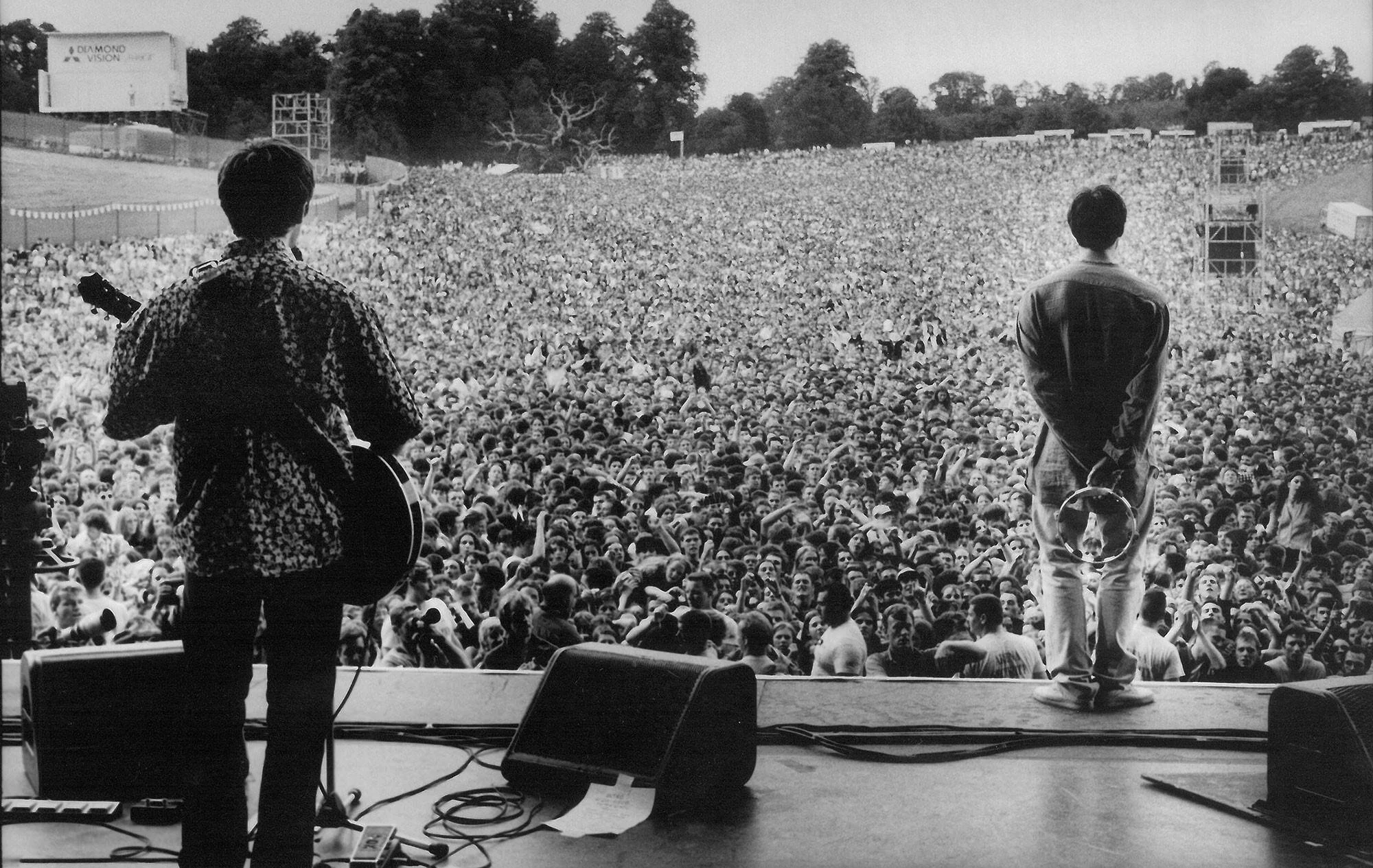 Oasis en vivo en el concierto de Knebworth 1996 frente a una multitud